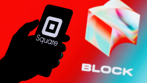 Square, Inc. changes name to Block (SQ).  Smartphone with square logo on the screen in hand on the background of the Block logo.