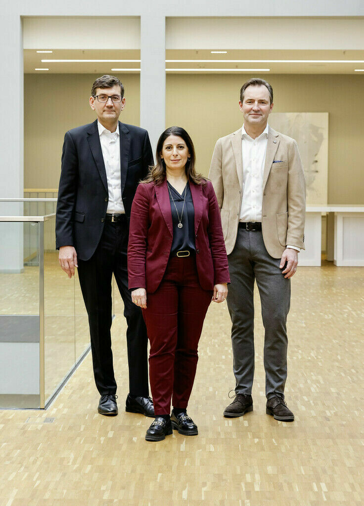 Three Volkswagen employees pose for a photo.