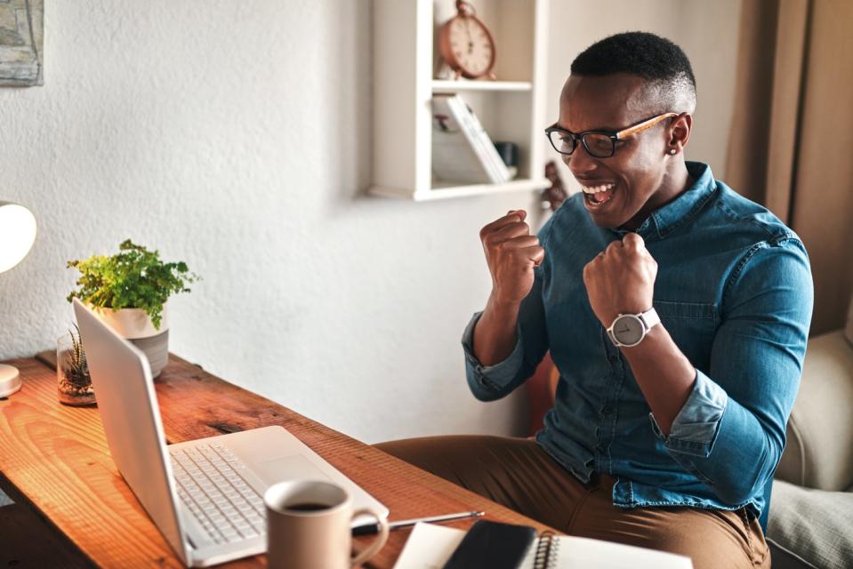 investor sitting at desk celebrating