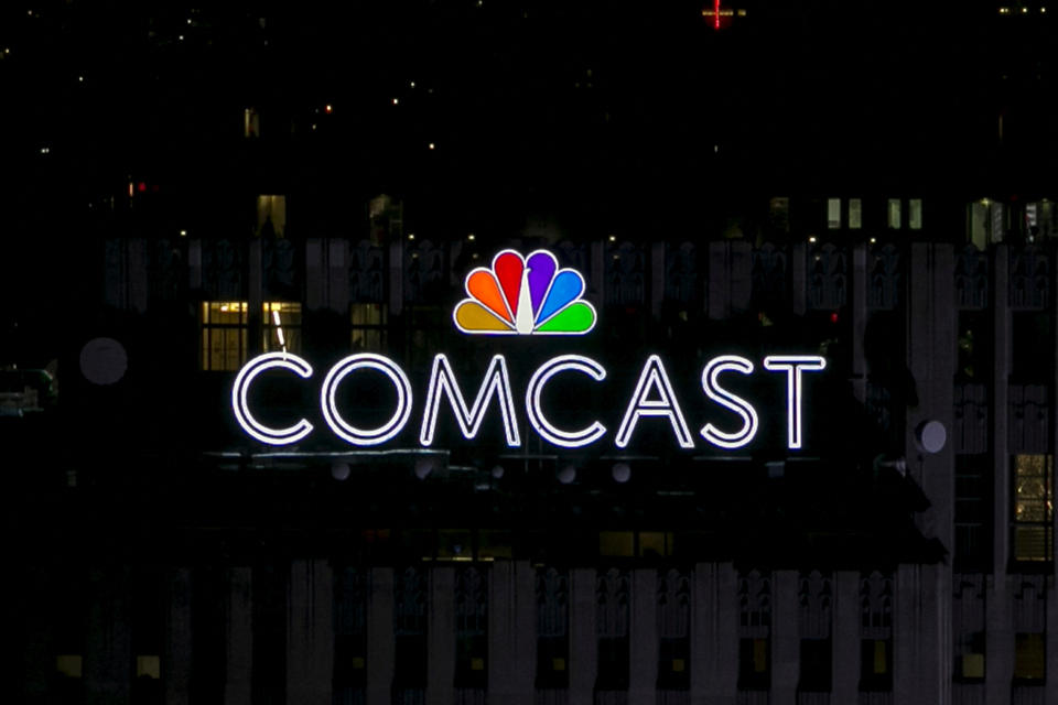 FILE PHOTO: The NBC and Comcast logo is displayed atop 30 Rockefeller Plaza, formerly known as the GE building, in midtown Manhattan, New York on July 1, 2015. The Art Deco skyscraper, also known as '30 Rock' and already displayed a large neon 'GE' unveiled the NBC Peacock logo and Comcast brand this week.  REUTERS/Brendan McDermid/File photo