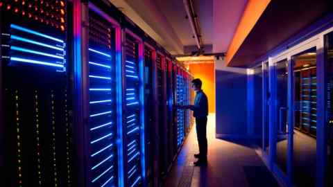 Modern interior of server room in datacenter.  IT engineer in action during server configuration