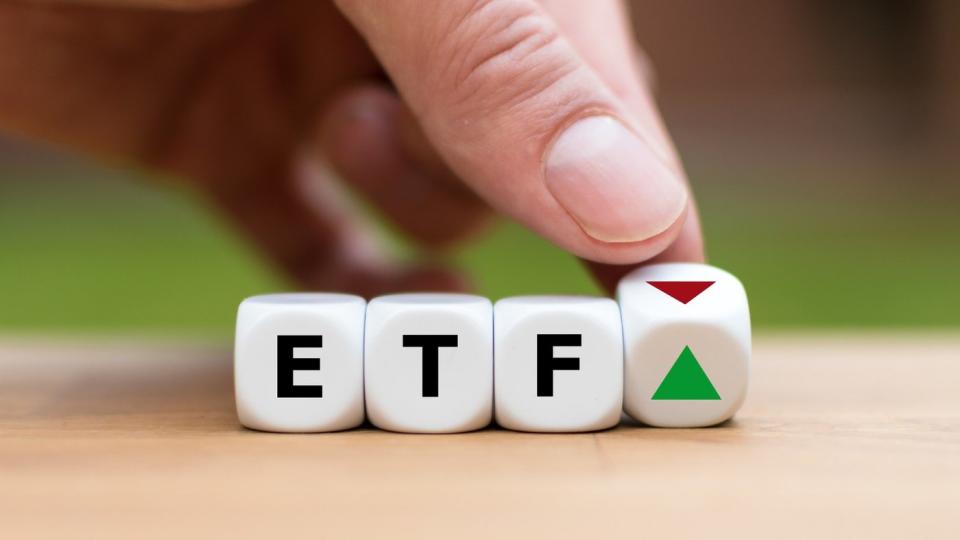 A finger spinning blocks that spell ETF.