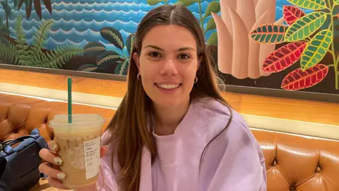 Maria Soare in a Starbucks cafe holds a cold drink