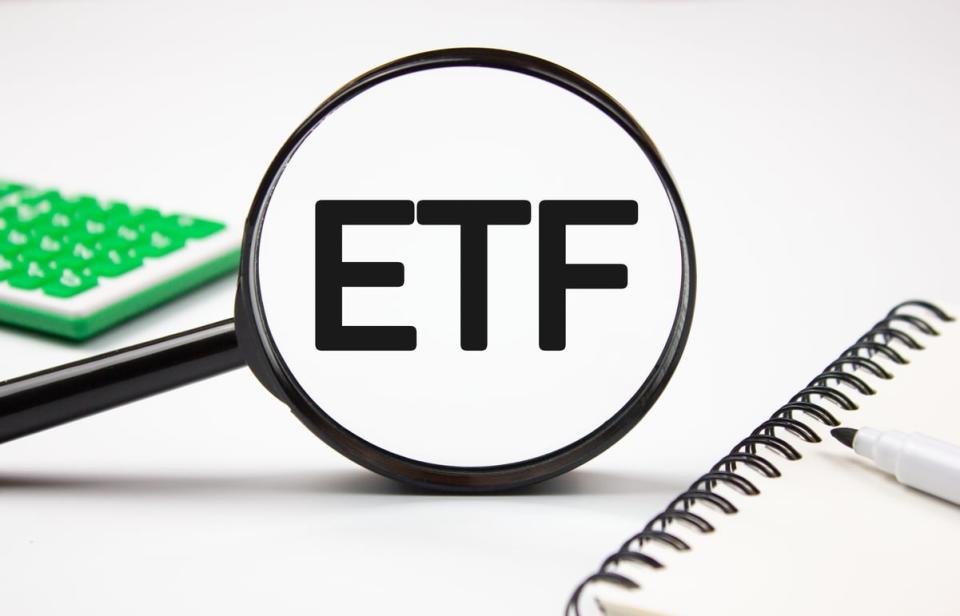 The letters ETF under a magnifying glass.