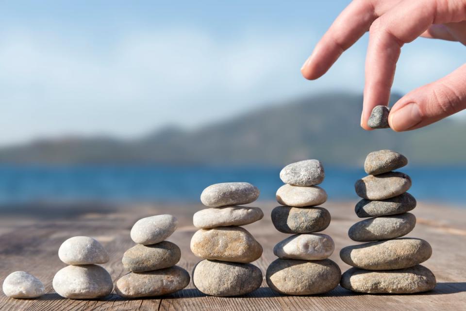 Person stacking stones in higher and higher towers.