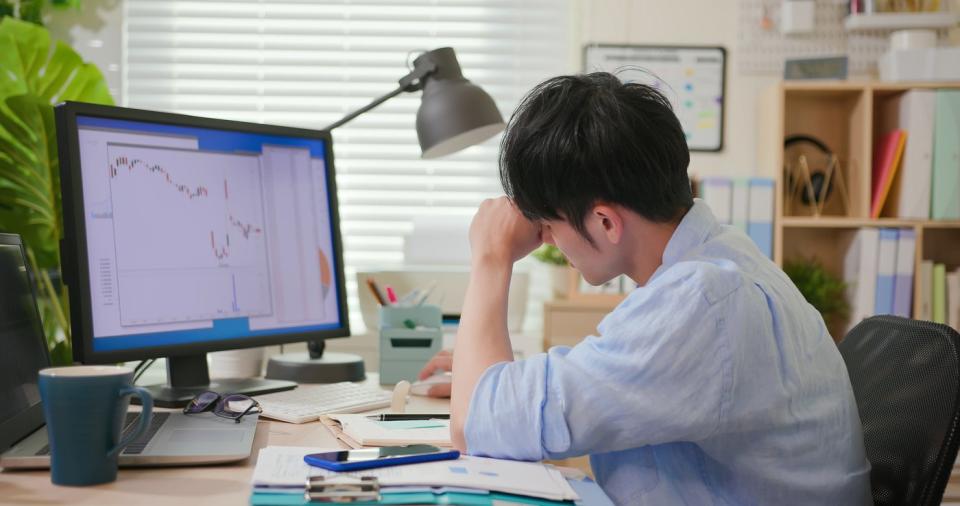 A person analyzes a stock chart on his computer. 