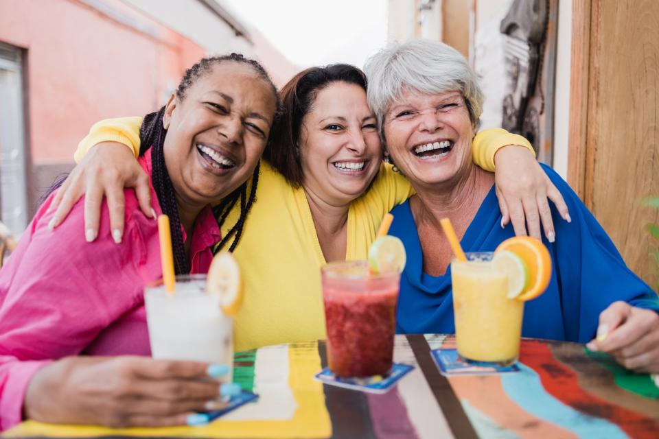 Three friends hug and smile. 