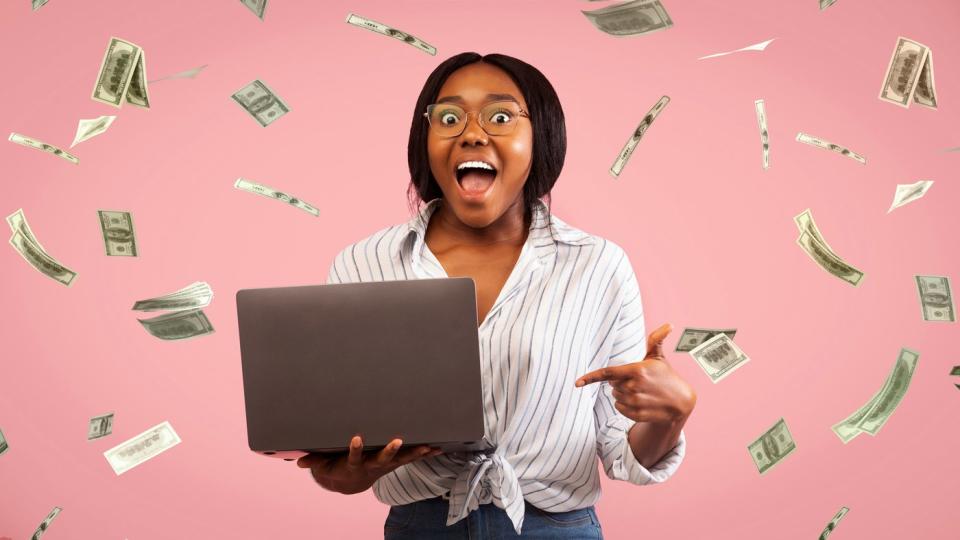 A person using a laptop receives cash.