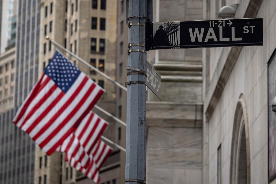 The Wall Street sign is seen with US flags outside the New York Stock Exchange in New York on June 16, 2022. (Photo by Yuki IWAMURA/AFP) (Photo by YUKI IWAMURA/AFP via Getty Images)