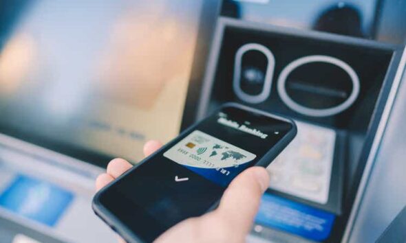Man at the ATM withdrawing money with smartphone