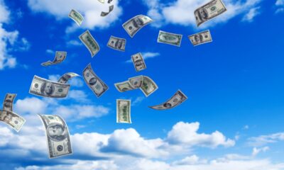 U.S. Money falling from a partly cloud sky.